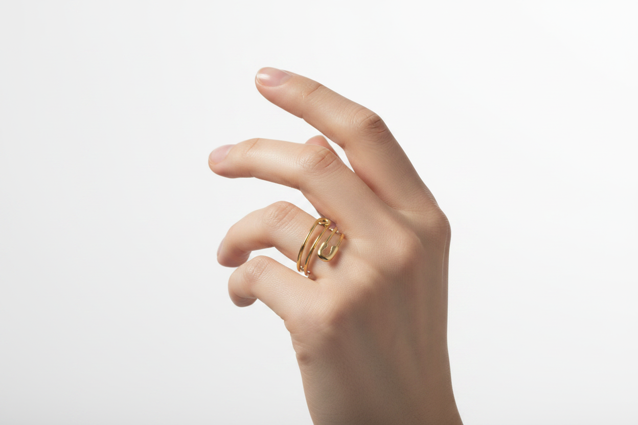 Bague épingle dorée sur main féminine fond lumineux